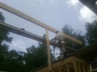 Carpenter setting a ridge beam over a new addition frame — Ice Dam Removal by Roofing Brothers in Port Sanilac