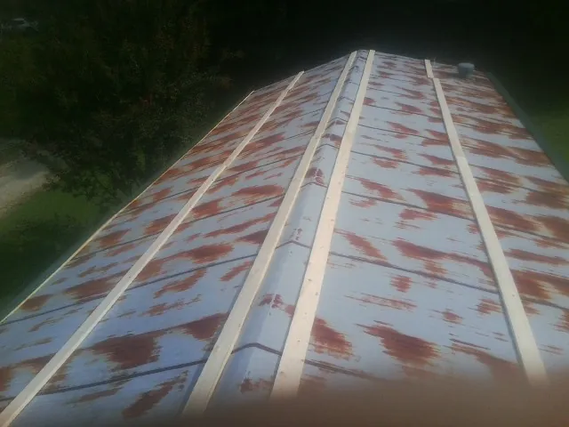 Rusted metal roof panels with new wood purlins before replacement — Storm Damage Roof Repair in Port Sanilac by Roofing Brothers
