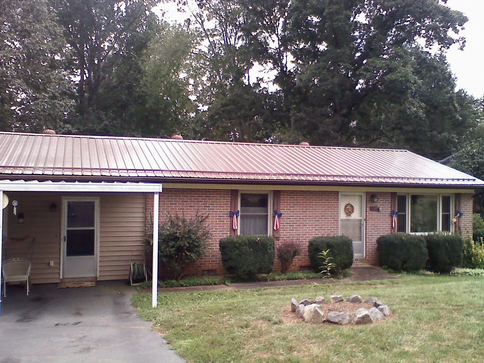 Bronze metal roof and carport on a brick ranch home — Roof Repair work by our crew in Port Sanilac