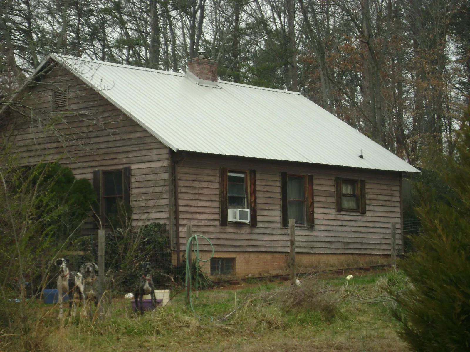 White metal roof on an old wood sided farmhouse, from a Metal Roof Installation job in Port Sanilac